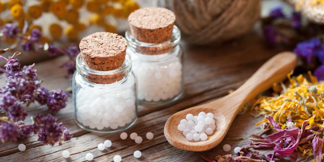 Das Foto zeigt zwei Fläschchen mit homöopathischen Kügelchen